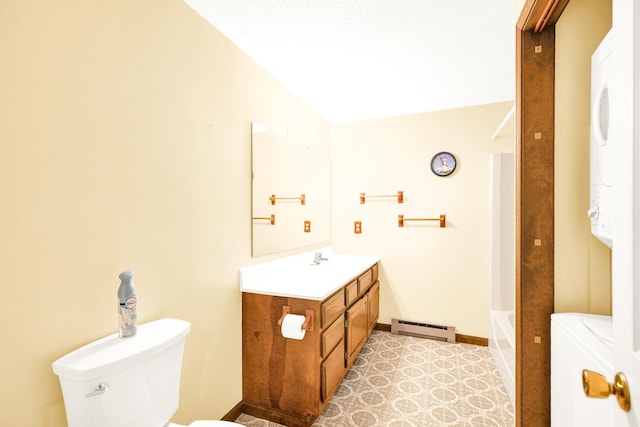 full bathroom featuring vanity, bathtub / shower combination, stacked washer and dryer, toilet, and a baseboard radiator