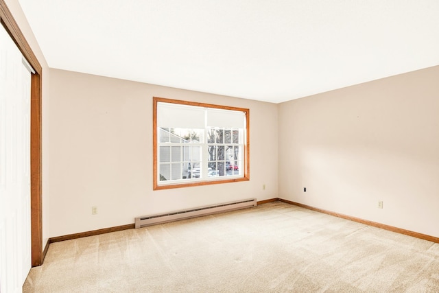 unfurnished room featuring light colored carpet and a baseboard heating unit