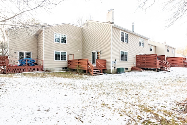 snow covered property with central air condition unit and a wooden deck