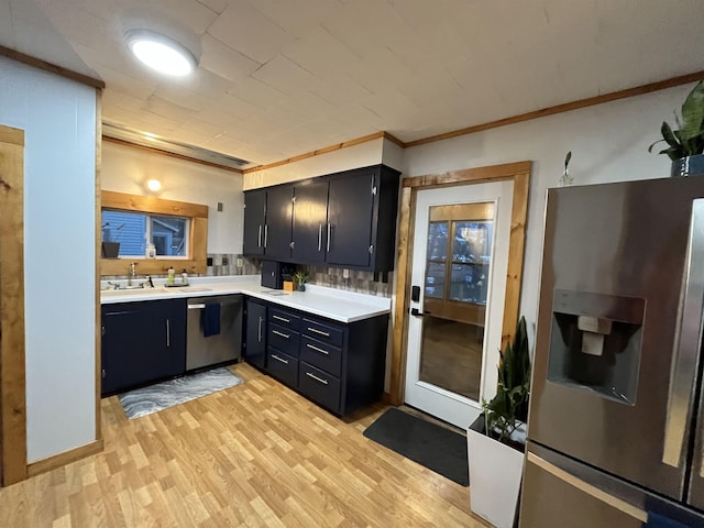 kitchen with sink, decorative backsplash, light wood-type flooring, ornamental molding, and stainless steel appliances