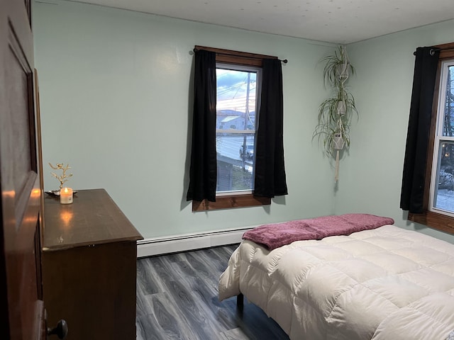 bedroom featuring dark hardwood / wood-style floors and a baseboard heating unit