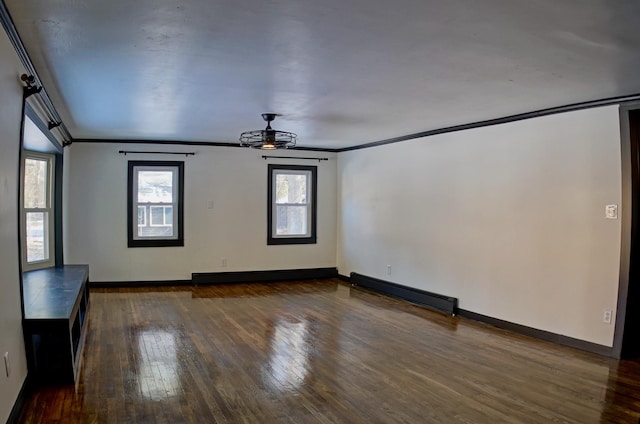 spare room featuring crown molding, dark hardwood / wood-style floors, a baseboard heating unit, and ceiling fan