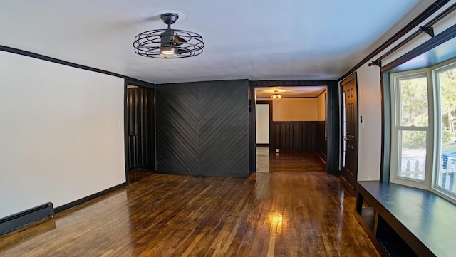 spare room featuring ceiling fan, a baseboard radiator, hardwood / wood-style floors, and crown molding