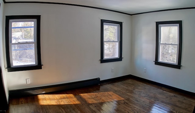 spare room featuring ornamental molding, plenty of natural light, a baseboard heating unit, and dark hardwood / wood-style flooring