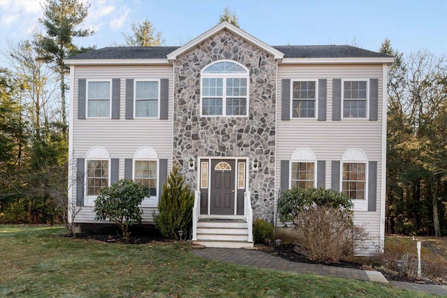 colonial inspired home featuring a front lawn