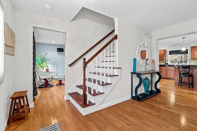 staircase featuring sink and wood-type flooring