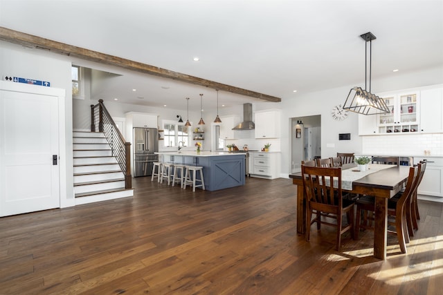 dining room with dark hardwood / wood-style floors, beam ceiling, and sink