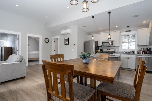 dining room with a wall mounted AC, light hardwood / wood-style flooring, and sink