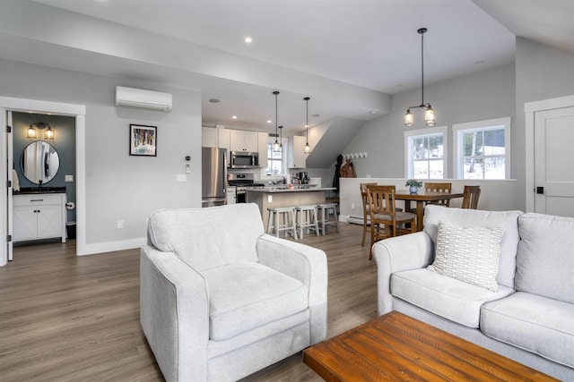 living room featuring a wealth of natural light, dark hardwood / wood-style flooring, and a wall mounted AC