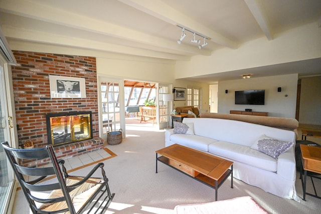 living room with beamed ceiling, a fireplace, carpet floors, and rail lighting