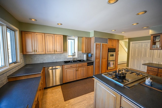 kitchen with backsplash, sink, stainless steel appliances, and plenty of natural light