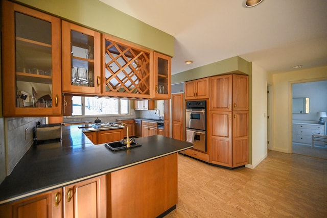 kitchen with kitchen peninsula, stainless steel appliances, and tasteful backsplash