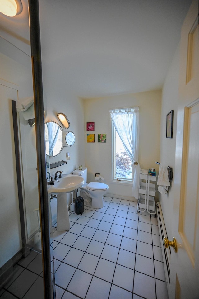 bathroom featuring toilet, a baseboard radiator, tile patterned floors, and sink