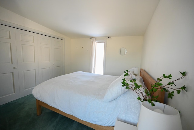 carpeted bedroom with a closet and vaulted ceiling