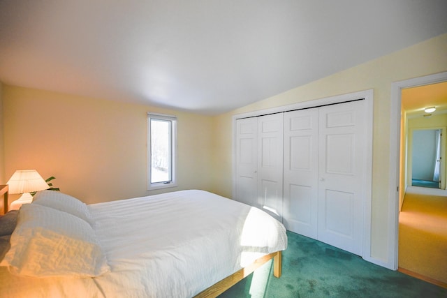 bedroom featuring a closet, lofted ceiling, and dark colored carpet