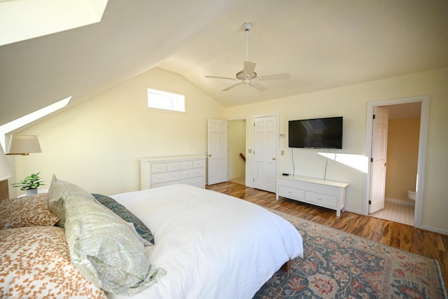 bedroom with hardwood / wood-style floors, ensuite bathroom, vaulted ceiling, and ceiling fan