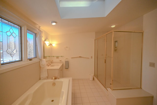 bathroom with tile patterned flooring, vanity, independent shower and bath, and a skylight