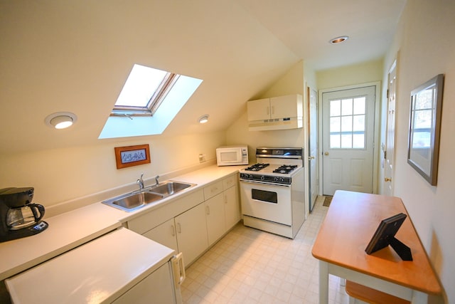 kitchen featuring cream cabinets, lofted ceiling with skylight, sink, and white appliances