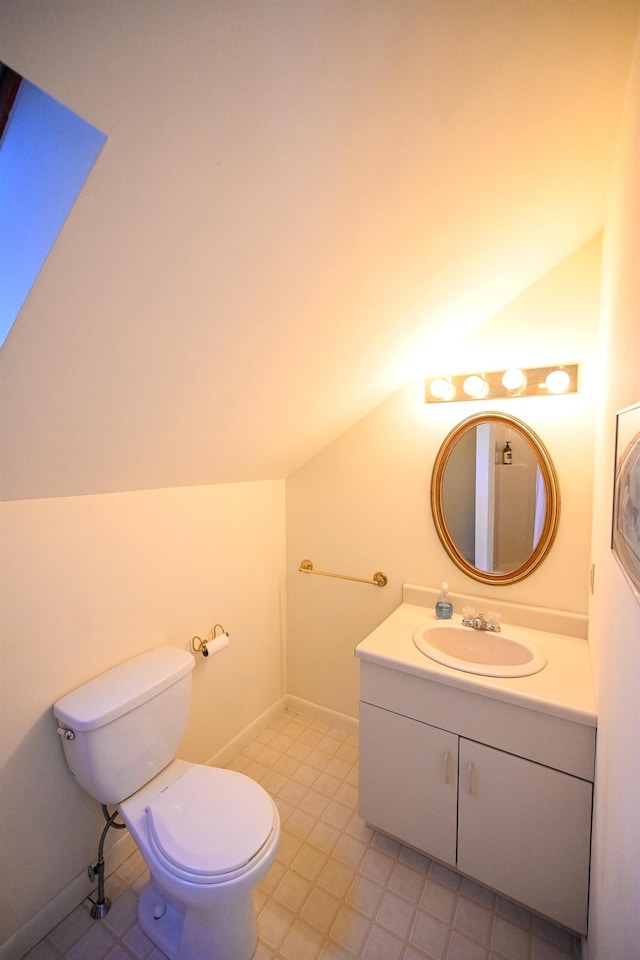 bathroom featuring vanity, toilet, and vaulted ceiling