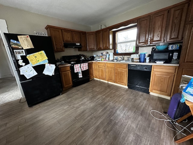 kitchen featuring dark hardwood / wood-style flooring, sink, and black appliances