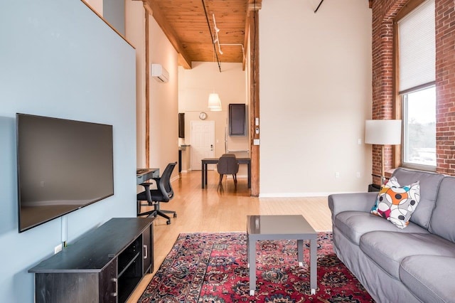 living room featuring beamed ceiling, a towering ceiling, light hardwood / wood-style flooring, and wooden ceiling