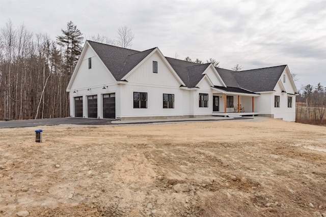 rear view of house with covered porch and a garage