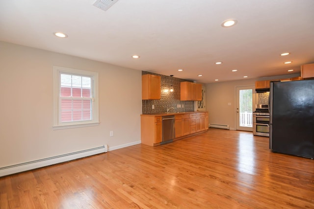 kitchen with a healthy amount of sunlight, stainless steel appliances, a baseboard radiator, and light wood-type flooring