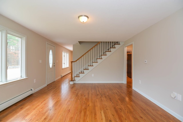 entrance foyer with baseboard heating and wood-type flooring