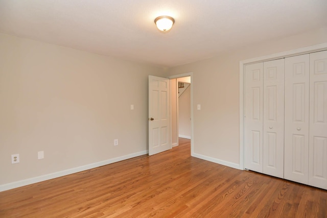 unfurnished bedroom featuring a closet and light hardwood / wood-style floors