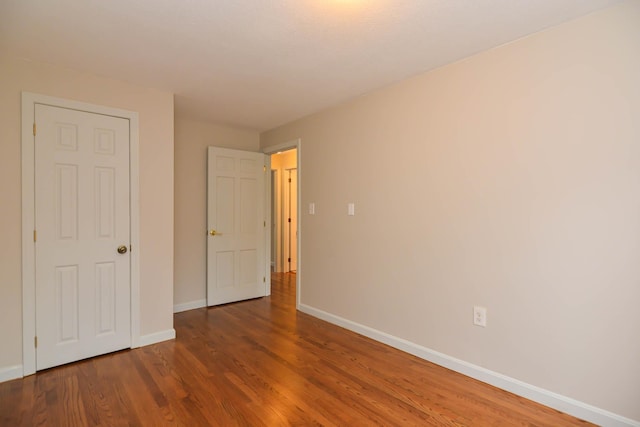 unfurnished bedroom with dark wood-type flooring