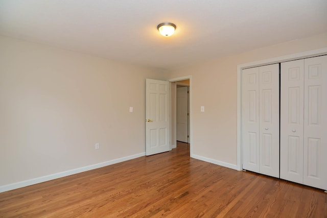 unfurnished bedroom with light hardwood / wood-style flooring and a closet