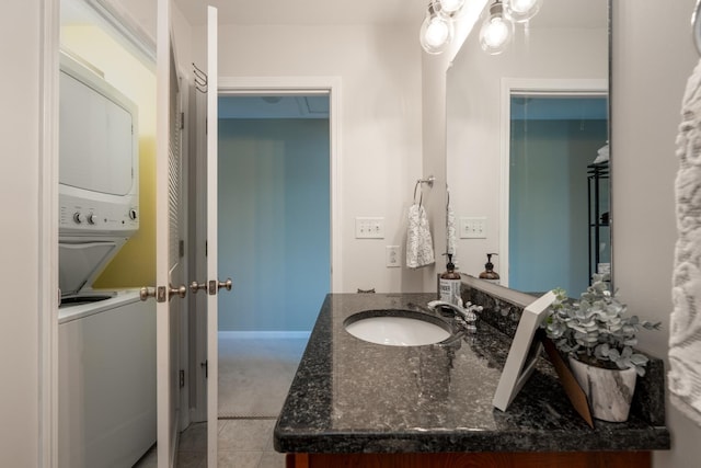 bathroom with vanity, stacked washing maching and dryer, and tile patterned floors