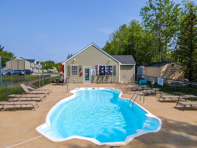 view of pool featuring a patio area and a shed