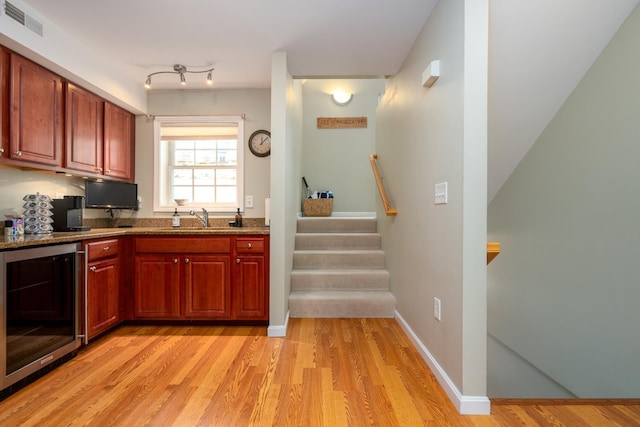 kitchen with light hardwood / wood-style flooring, wine cooler, and sink