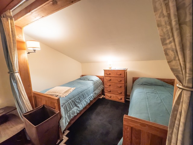 bedroom with dark carpet and lofted ceiling