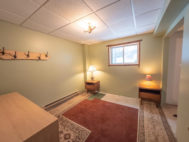 interior space featuring a paneled ceiling and a baseboard heating unit