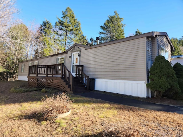 exterior space featuring a front lawn and a wooden deck