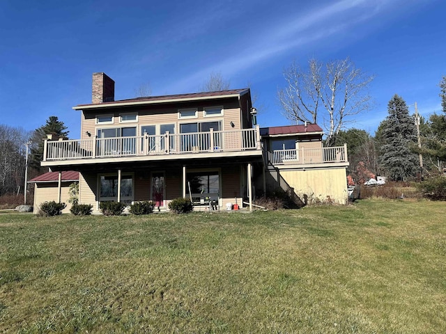 rear view of property featuring a deck and a lawn