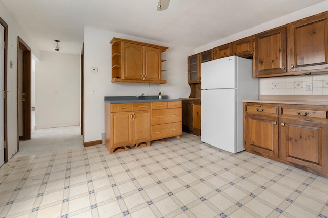 kitchen with decorative backsplash and white refrigerator