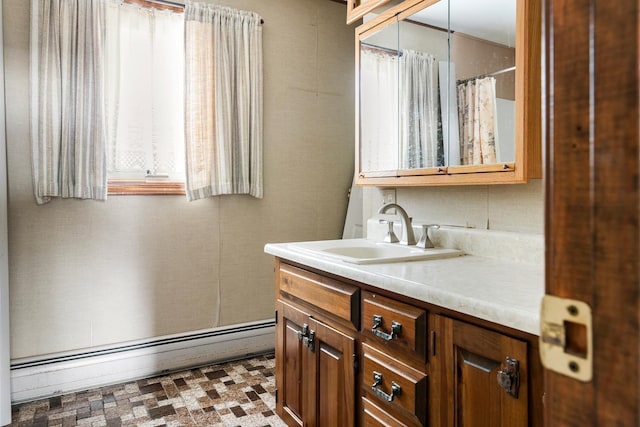 bathroom featuring baseboard heating and vanity