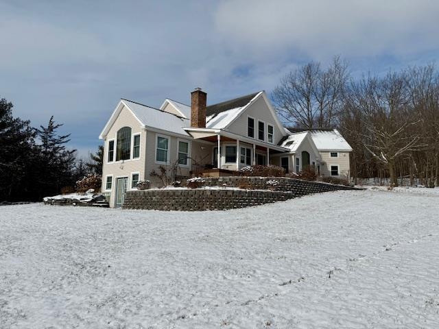 view of snow covered back of property