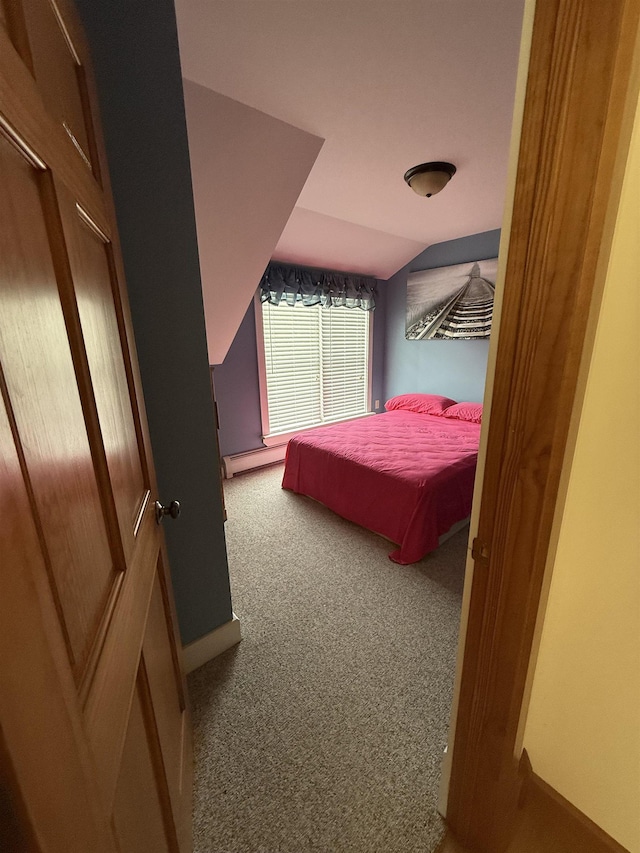 carpeted bedroom featuring a baseboard radiator and vaulted ceiling