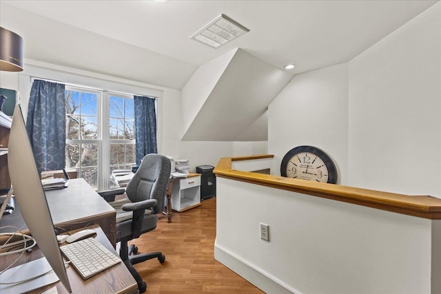 home office with wood-type flooring and vaulted ceiling