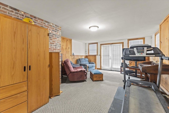 exercise room with carpet and wood walls