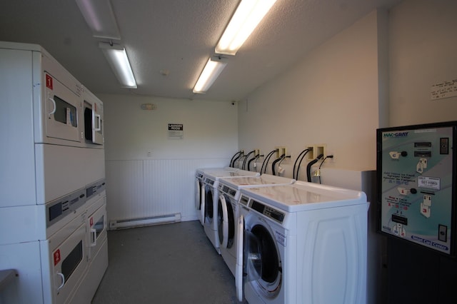 clothes washing area with a textured ceiling, separate washer and dryer, a baseboard radiator, and stacked washer / drying machine