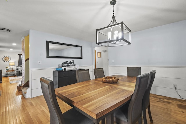 dining room with light hardwood / wood-style flooring and an inviting chandelier