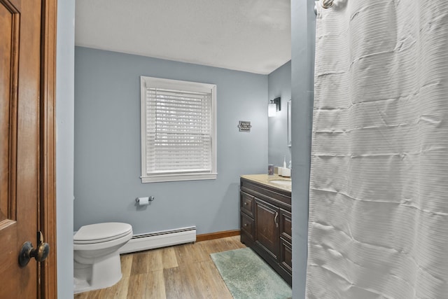 bathroom with toilet, vanity, a baseboard radiator, and hardwood / wood-style flooring