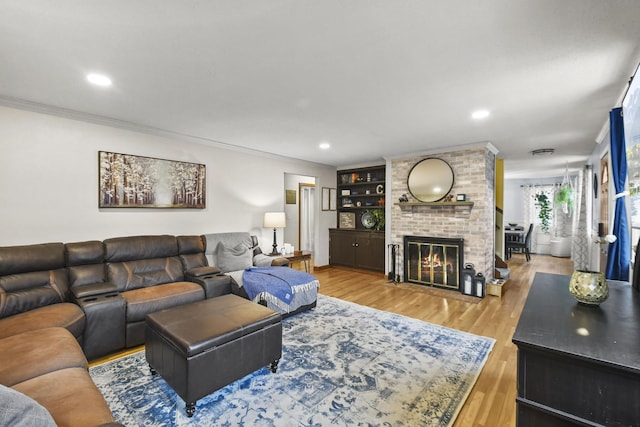 living room with a fireplace, hardwood / wood-style floors, built in features, and crown molding