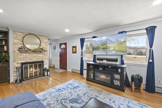 living room with a baseboard radiator, hardwood / wood-style flooring, a brick fireplace, and crown molding