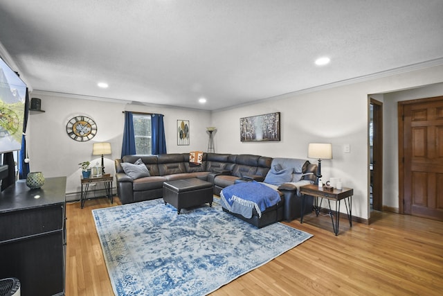 living room with ornamental molding, a textured ceiling, hardwood / wood-style flooring, and a baseboard heating unit